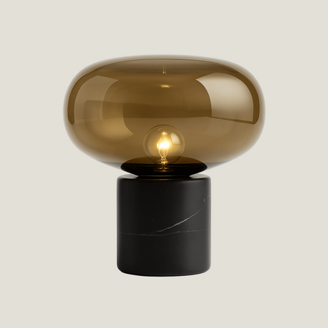 Bastion table lamp from Love Hohm with a smoked glass shade and black base on a light gray background