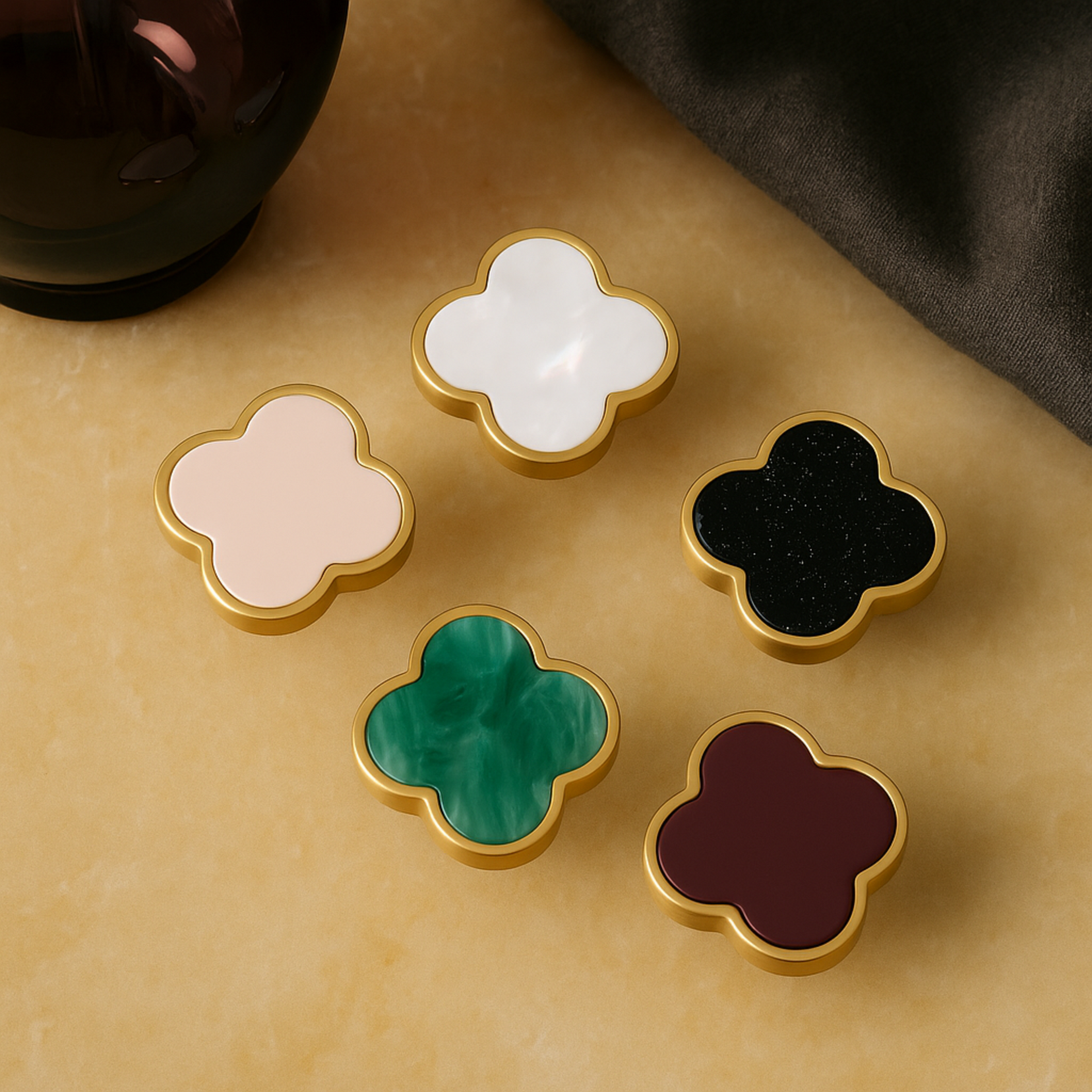 Charmant knob handles from Love Hohm in different colors on a beige surface.