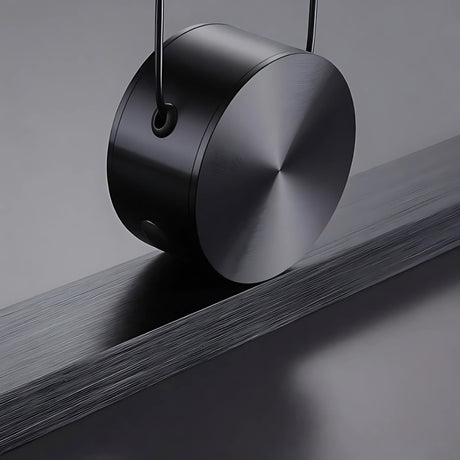 Chord pendant light from Love Hohm on a reflective surface with a dark background