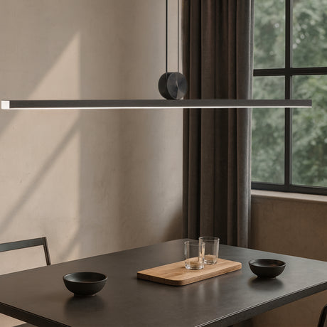 Chord pendant light by Love Hohm hanging above a dining table with minimal decor.