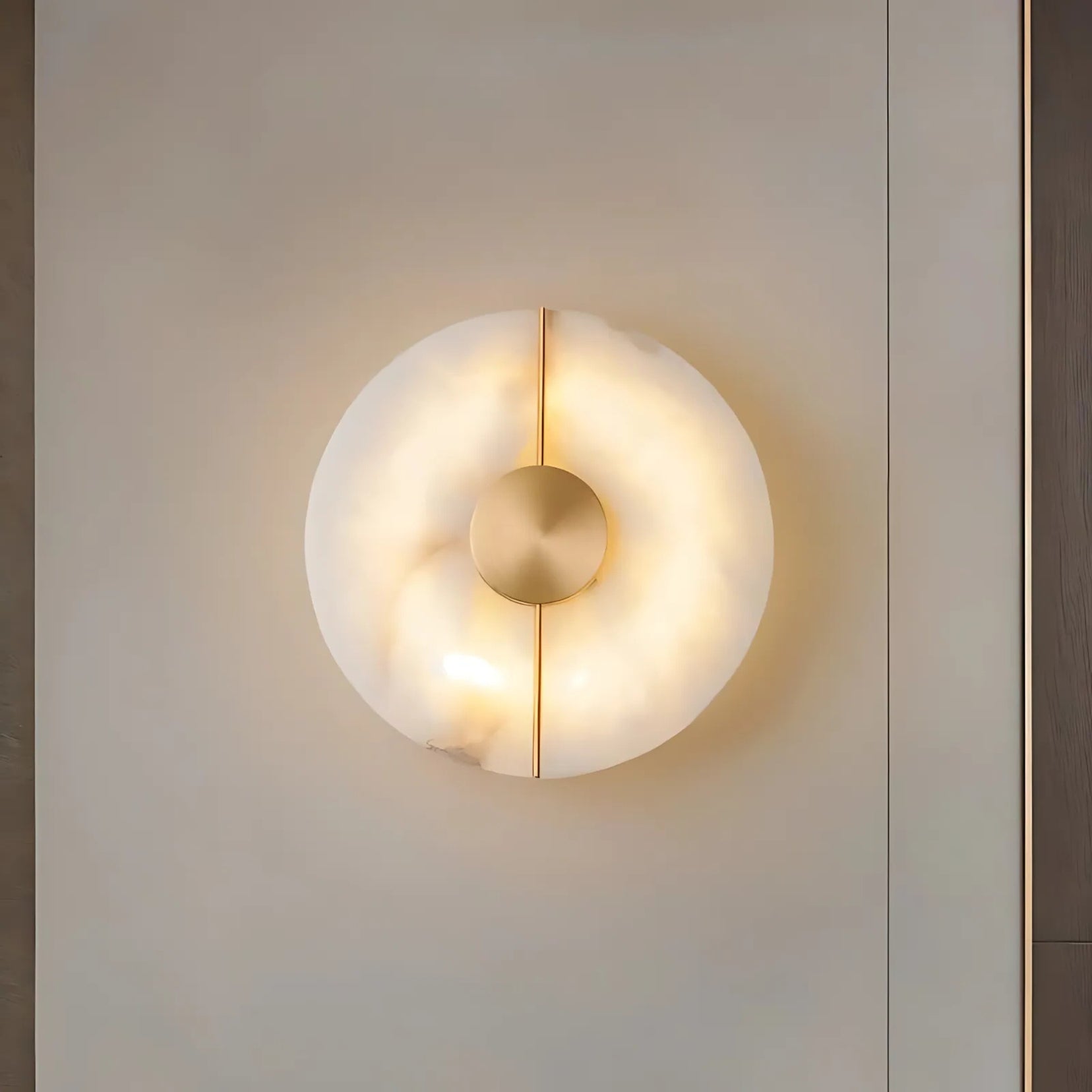 Corestone alabasterwall lamp from Love Hohm with a circular design on a neutral wall.