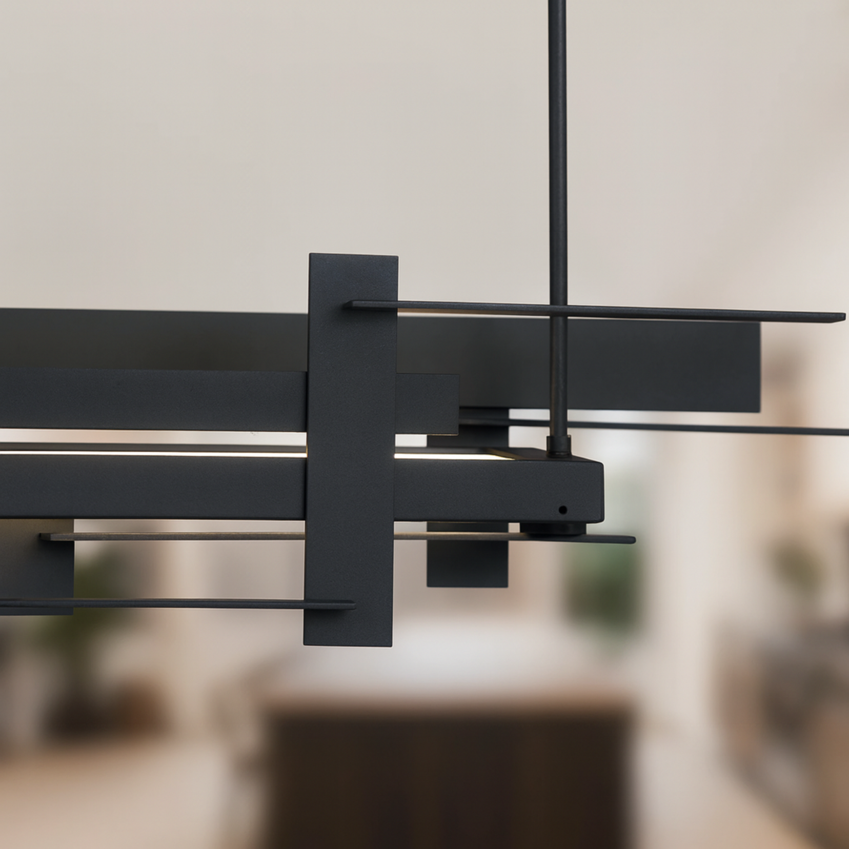 Modern Forge chandelier by Love Hohm against a blurred indoor background