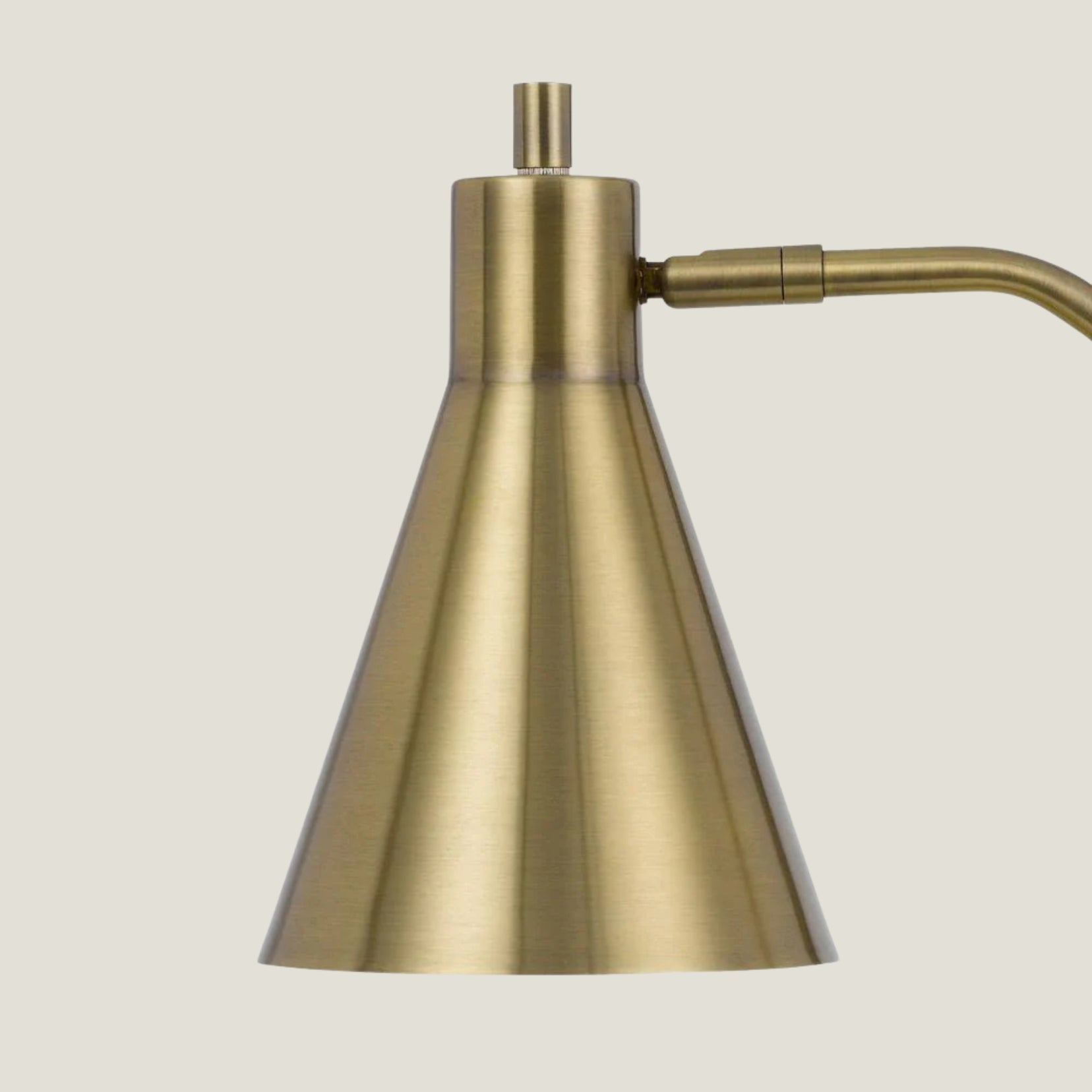 Formant brass lamp from Love Hohm with a conical shade on a light gray background