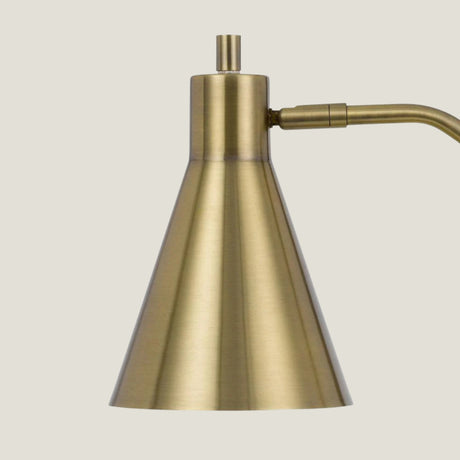 Formant brass lamp from Love Hohm with a conical shade on a light gray background