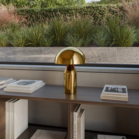 Gold table lamp on a shelf with books