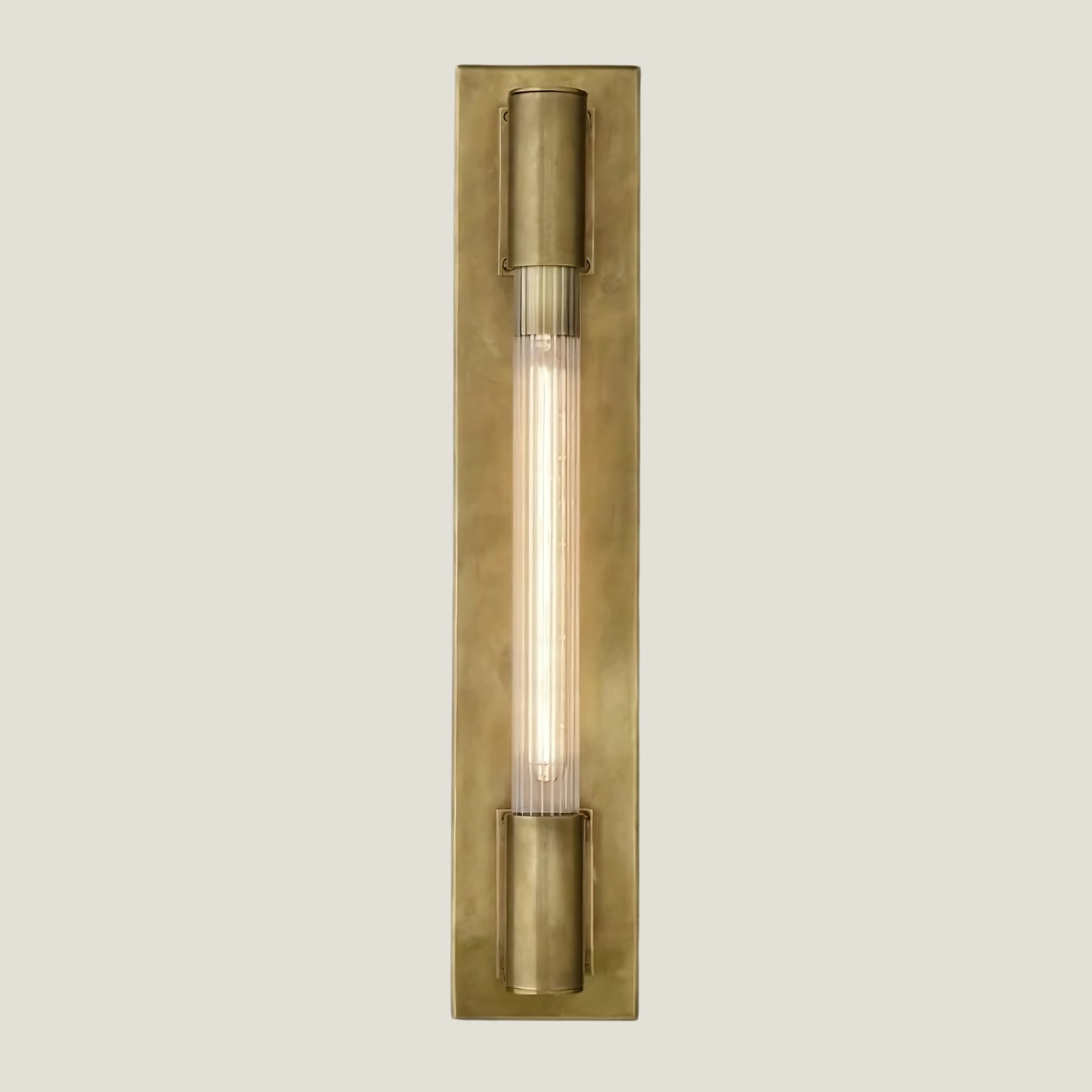 Gilt brass wall lamp from Love Hohm on a beige background