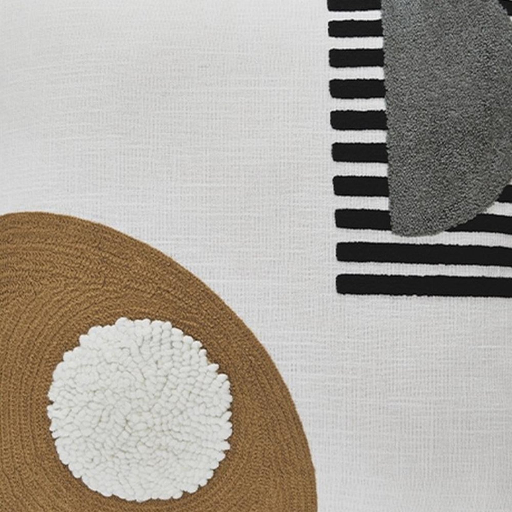 Close-up of a Glyph pillow from Love Hohm textured surface with geometric patterns including circles, stripes, and a pom-pom.