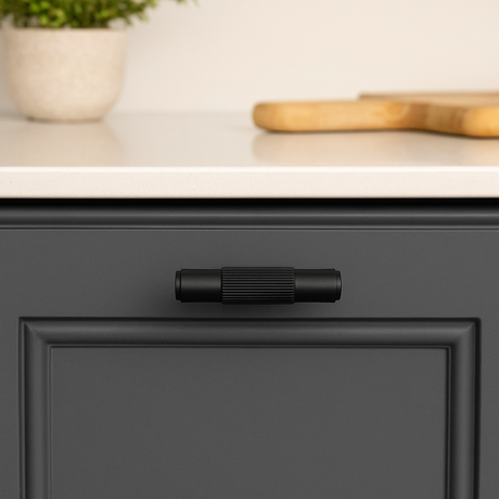 Hone t-knob in black from Love Hohm on a black kitchen cabinet.