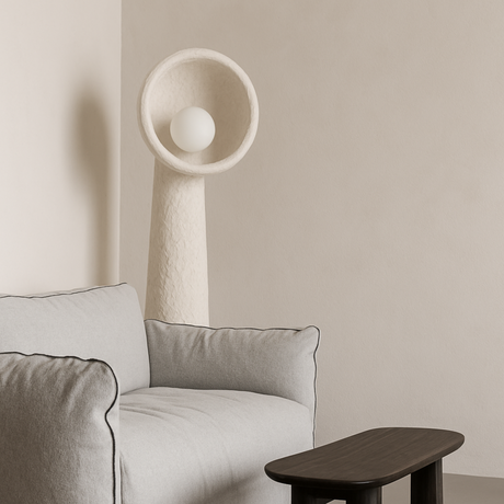 Modern interior with a light gray sofa, wooden side table, and a Lodestar Big Floor Lamp from Love Hohm against a beige wall.