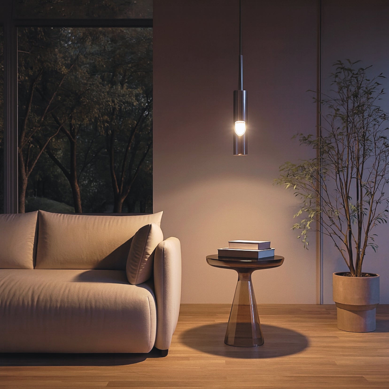 Modern Loom pendant from Love Hohm living room with a beige sofa, small round table, and potted plant.