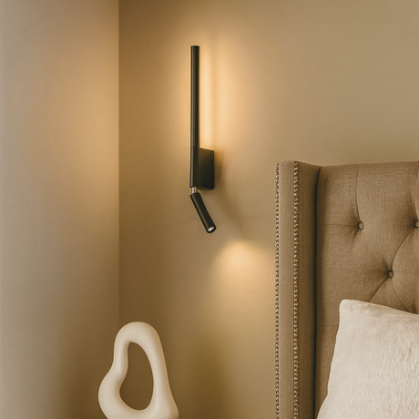 Mast wall-mounted lamp from Love Hohm on a beige wall next to a upholstered headboard with a pillow.