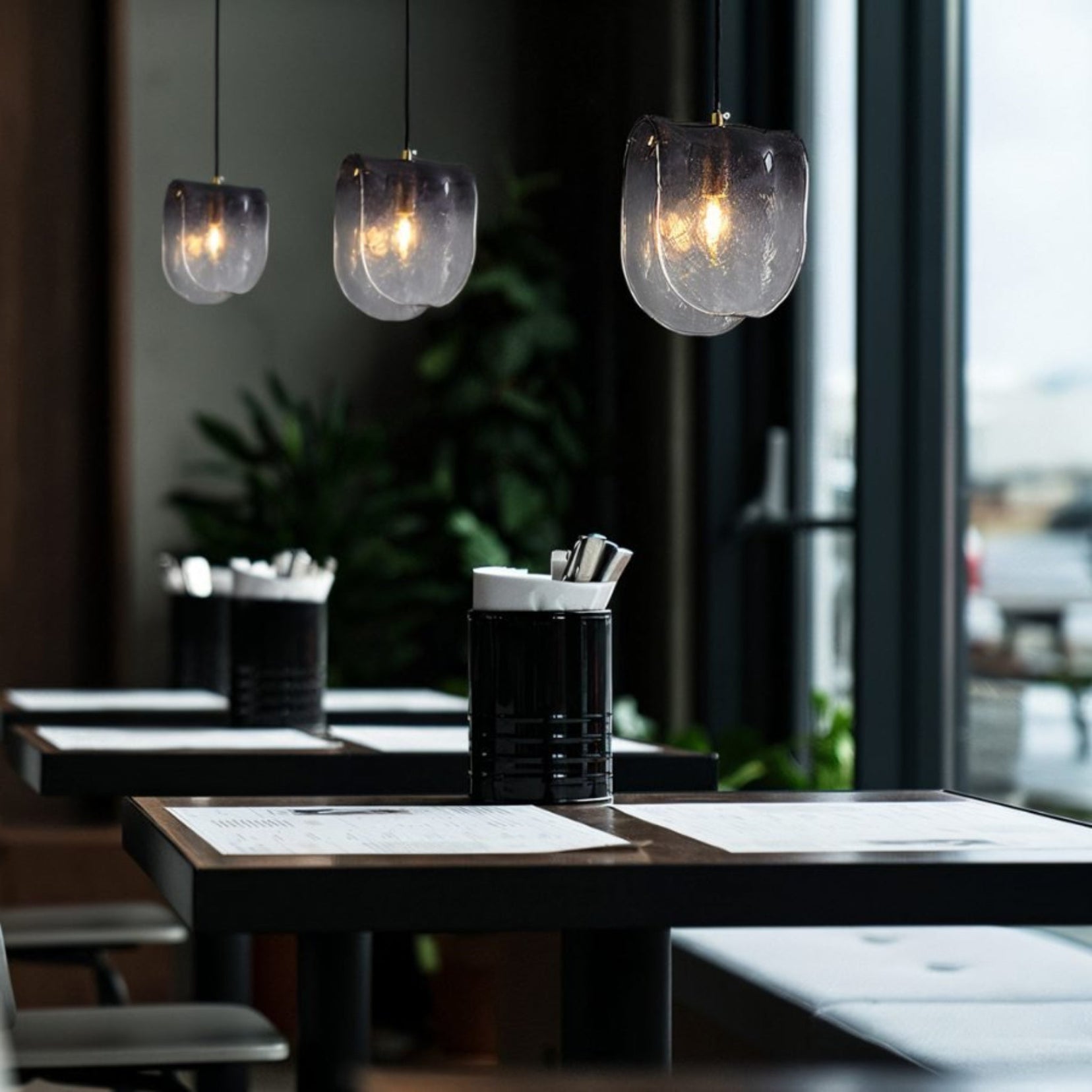 Three Obex pendants from Love Hohm in a restaurant dining setting.