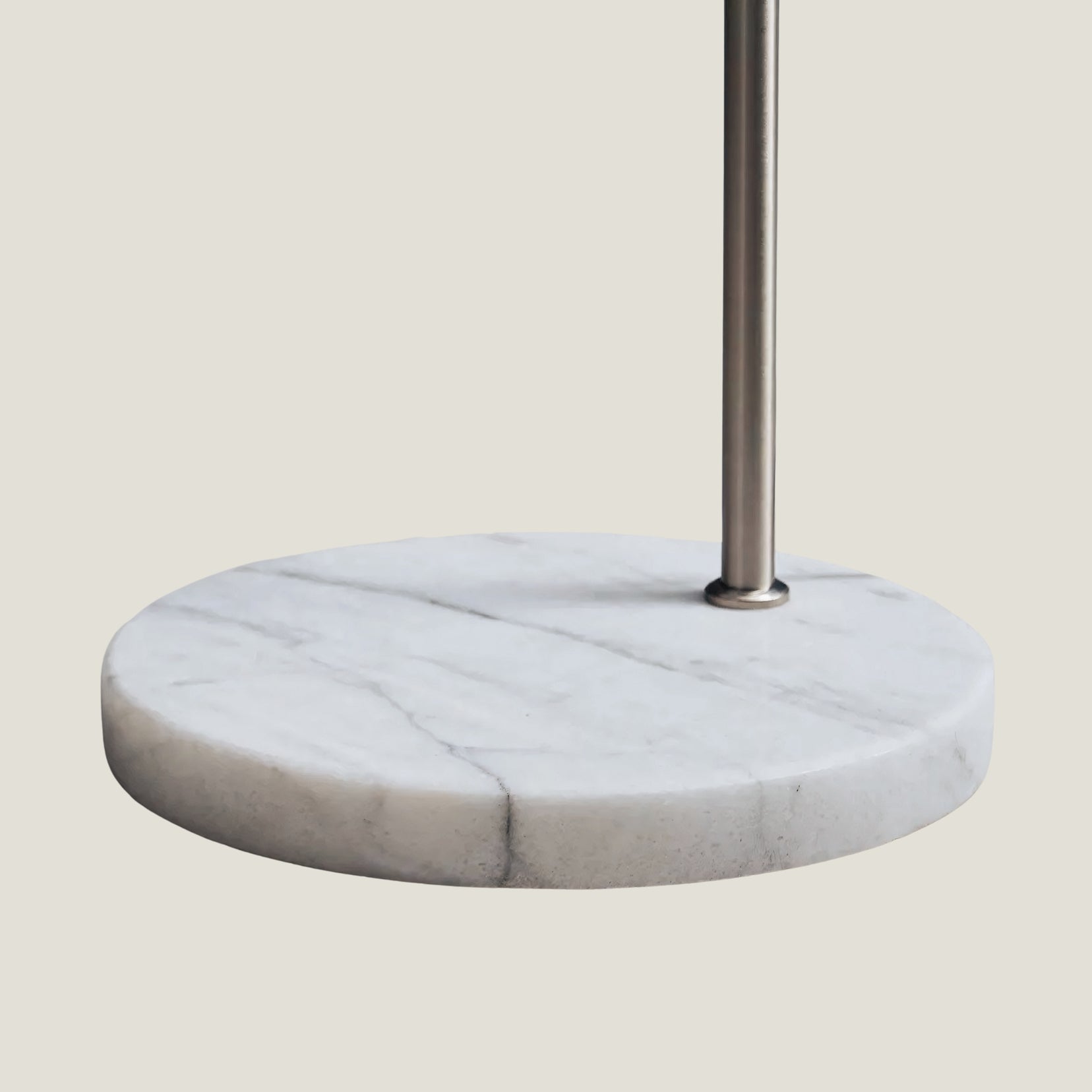 Overture arc floor lamp from Love hohm, marble base with metal stand on a light gray background