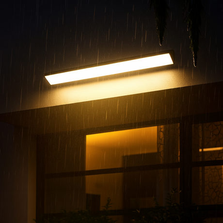 Quill outdoor wall lamp from Love Hohm on a building exterior during rain at night