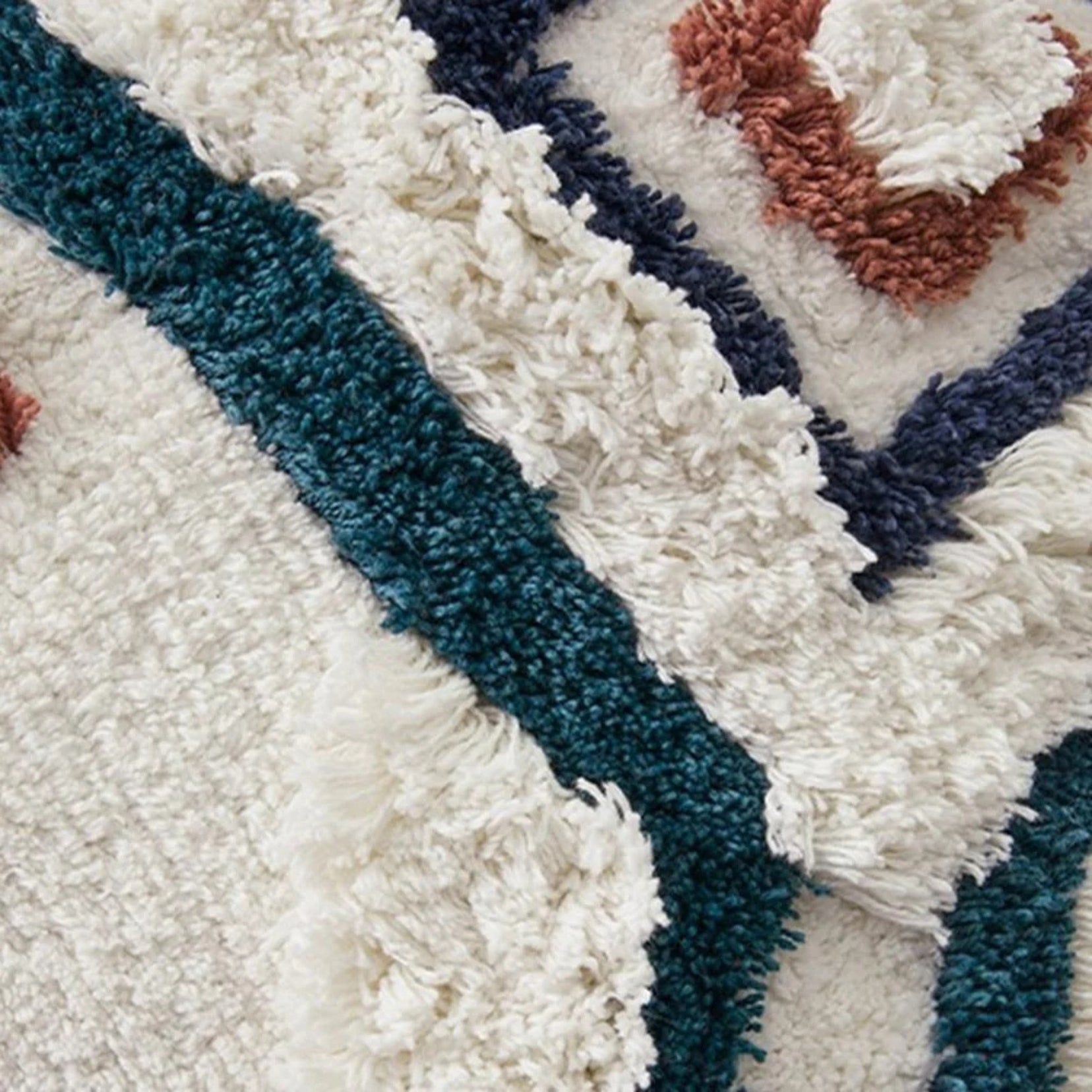 Close-up of a textured Stillwater accent pillow from Love Hohm with blue, white, and brown patterns