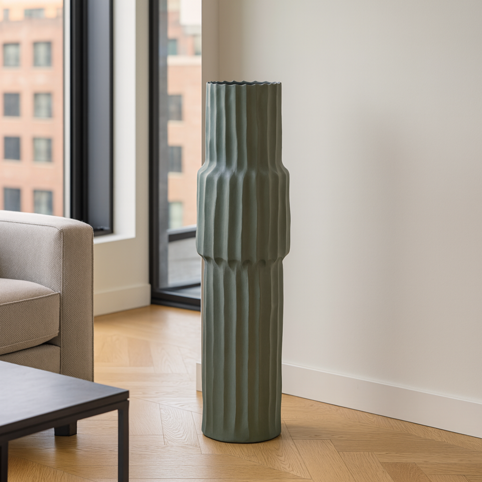 Tellure green textured floor vase from Love Hohm on a wooden floor in a living room with large windows.