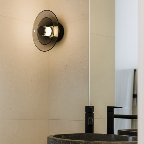 Bathroom sink with black faucet and Tondo light fixture on beige wall