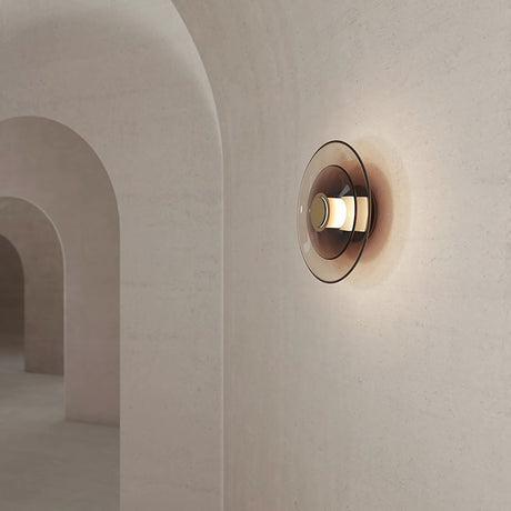 Modern Tondo wall light fixture on a neutral beige wall with architectural arches in the background