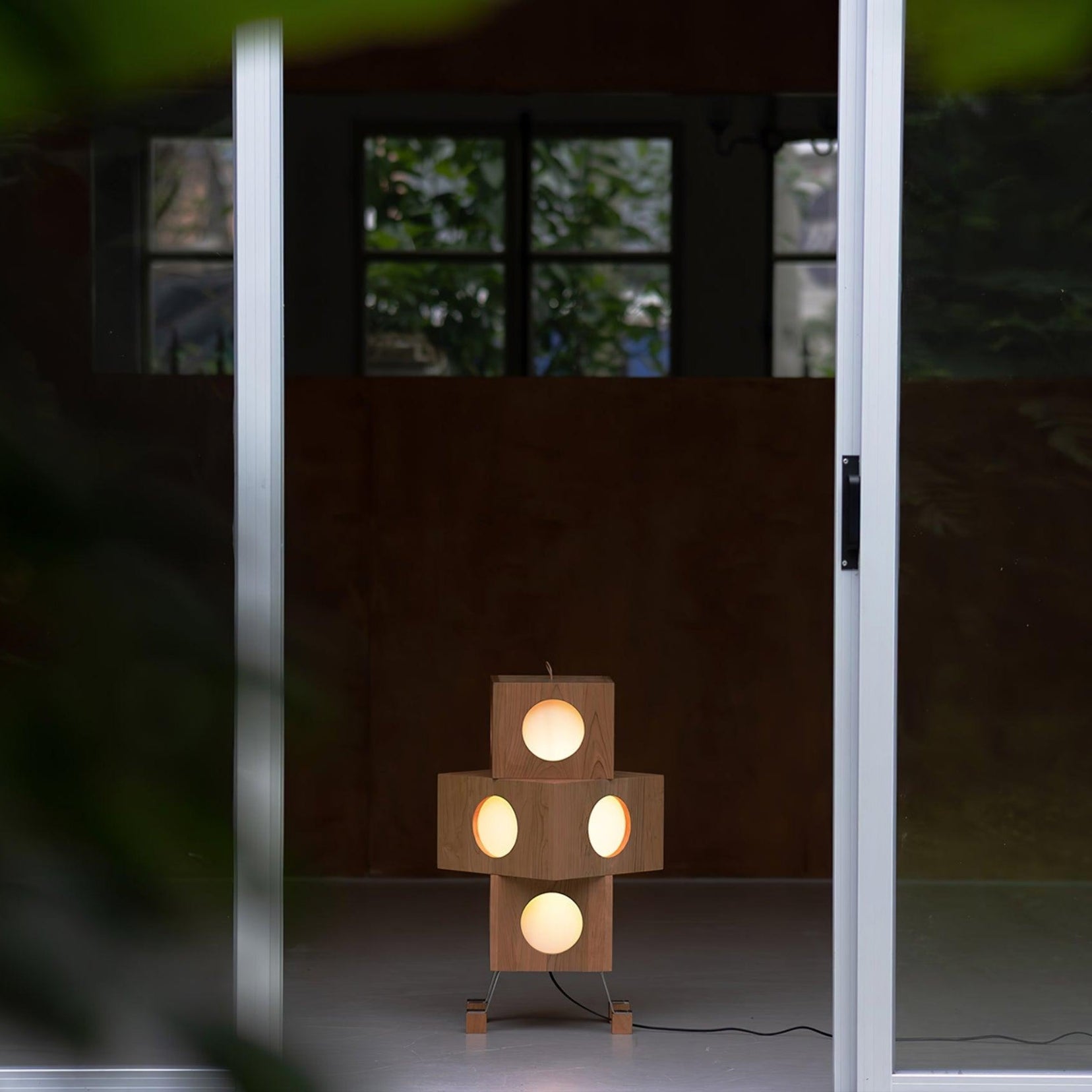 Torii floor lamp from Love Hohm with multiple circular lights in a dimly lit room.