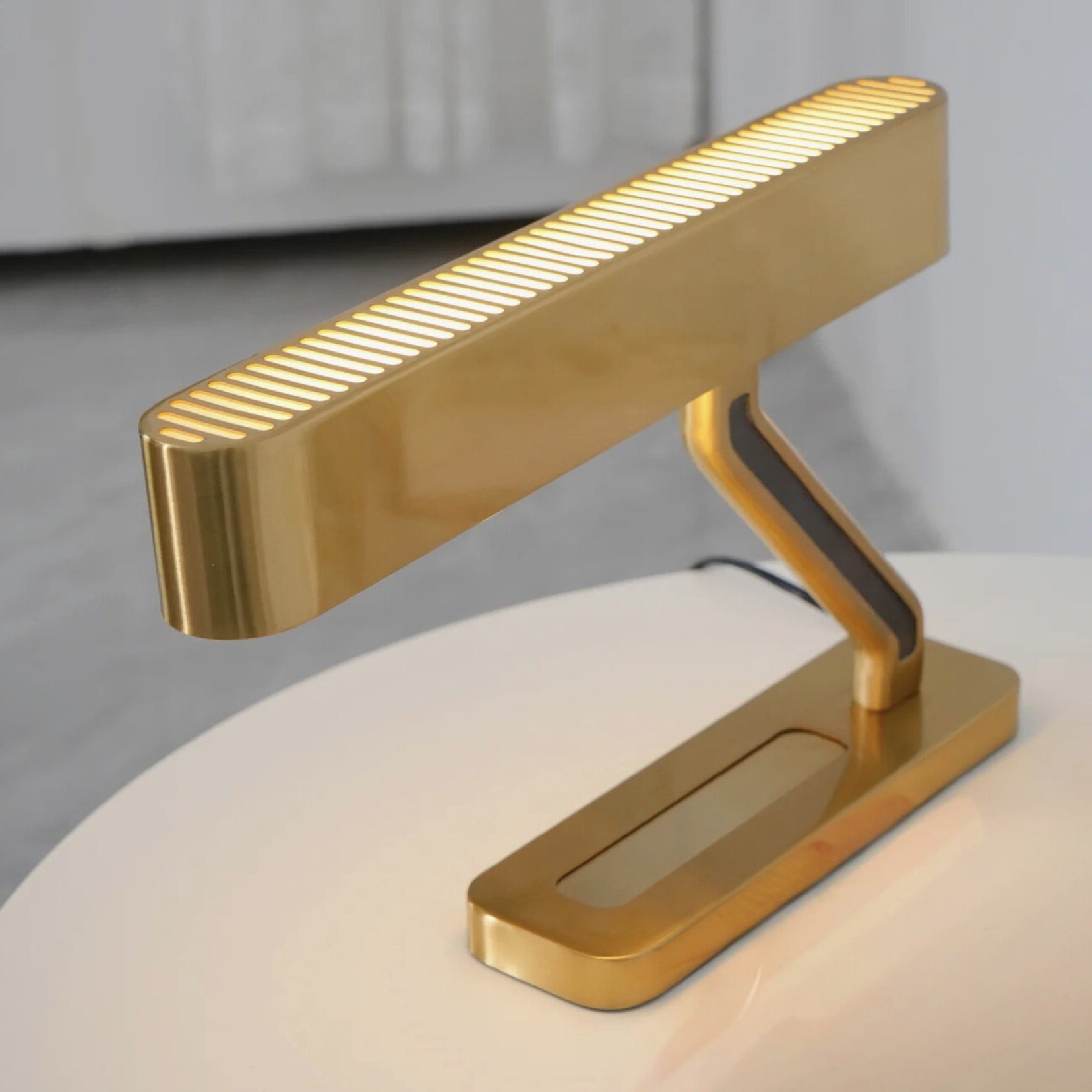 Vector brass desk lamp from Love hohm on a white surface with a blurred background