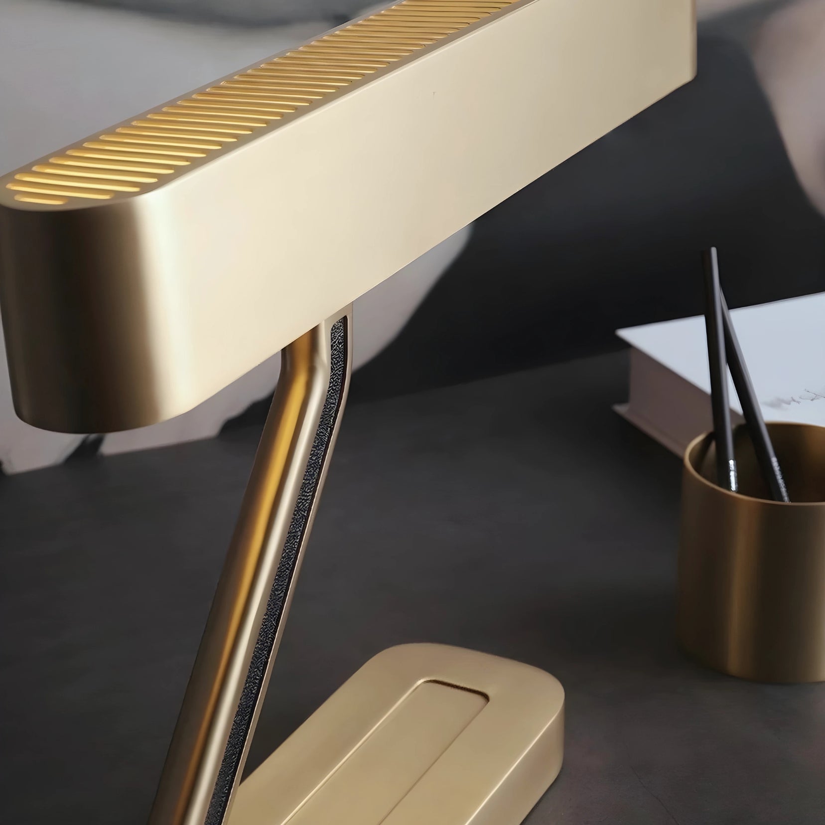 Vector brass desk lamp from Love Hohm on a dark surface with a blurred background
