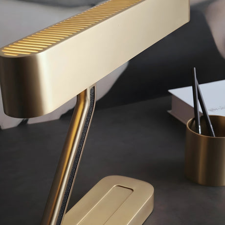 Vector brass desk lamp from Love Hohm on a dark surface with a blurred background