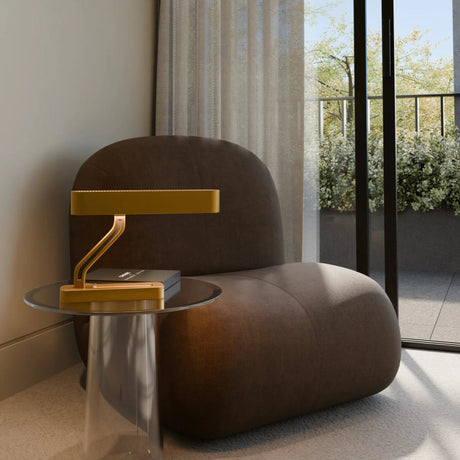 Modern interior with a brown armchair and brass Vector desk lamp by Love Hohm