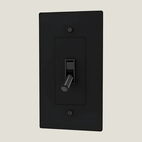 Verge brass toggle in matte black from Love Hohm on a beige background